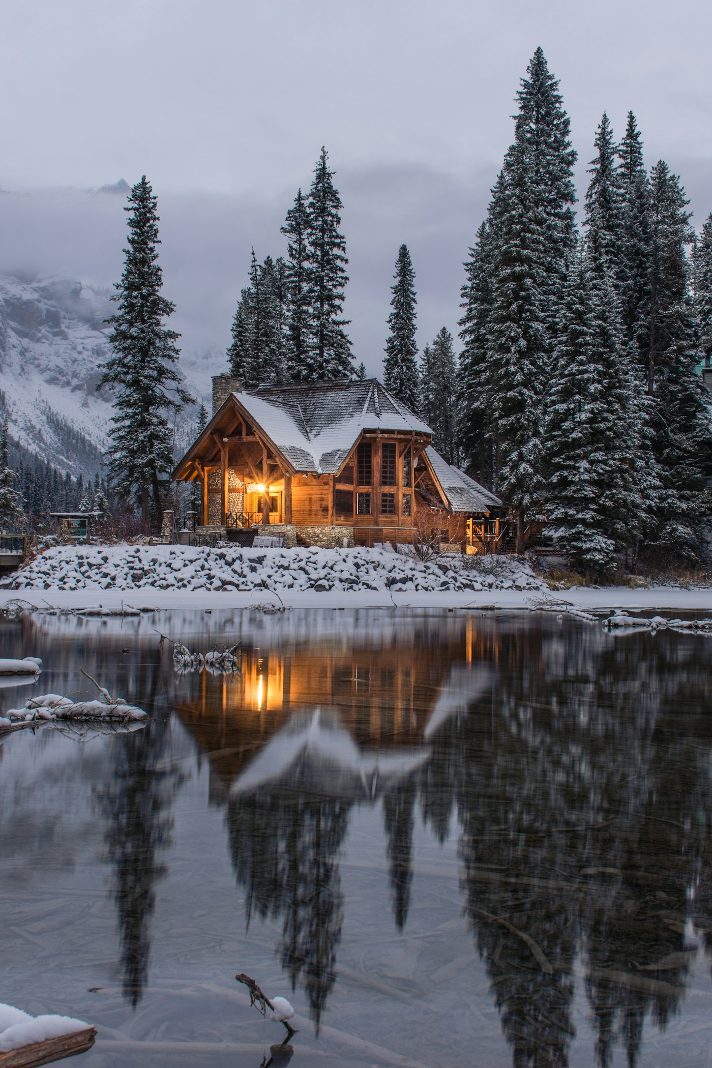 Warm cabin light reflected in a still woodland pond